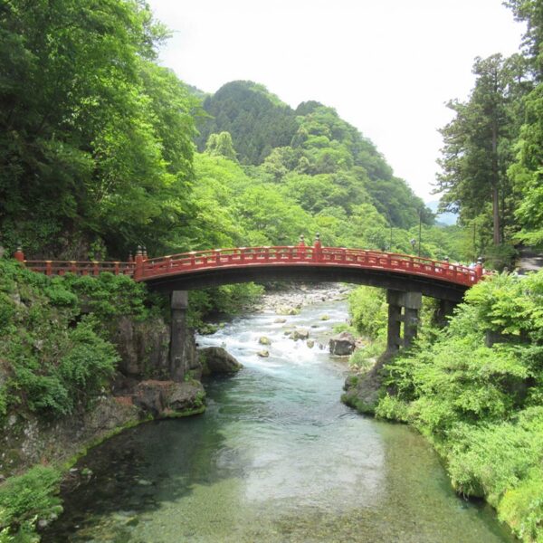 周囲の豊かな緑と朱色のコントラストが美しい神橋。日光の山々から落ちる流れを集め、中禅寺湖と華厳滝を経て流れる大谷川にかかる。　写真AC