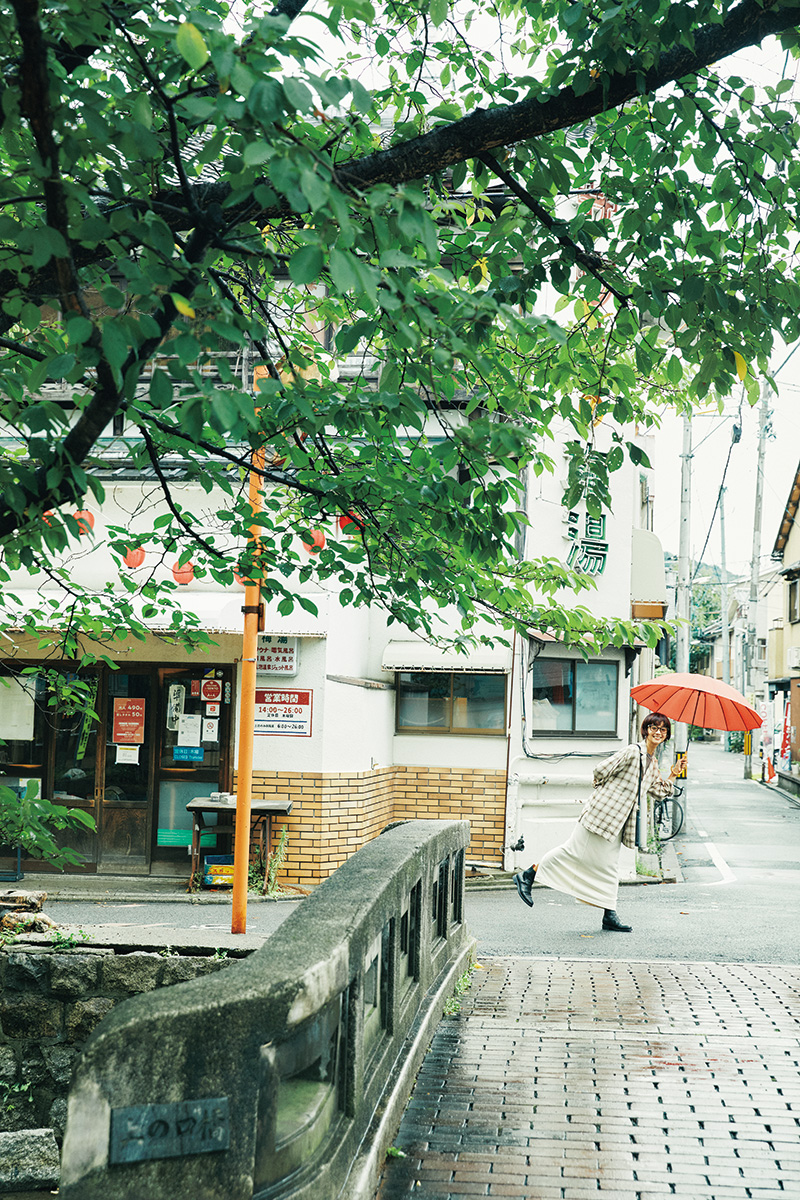 京都の古い街並みに合わせて、知的なイメージのメガネを主役にしてコーディネート。待ち合わせの目印に、赤い傘が役立った。ジャケット39,600円（un/un
bient）、トップス7,150円、スカート16,500円（共にLIFiLL）、ボールネックレス14,300円、フープピアス6,050円（共にBASENOTES）、眼鏡55,000円（YUIC
HI TOYAMA.）、シューズ85,800円、ショルダーバッグ64,900円（共にforme︱全てPARK parkkyoto@icloud.com）／その他スタイリスト私物