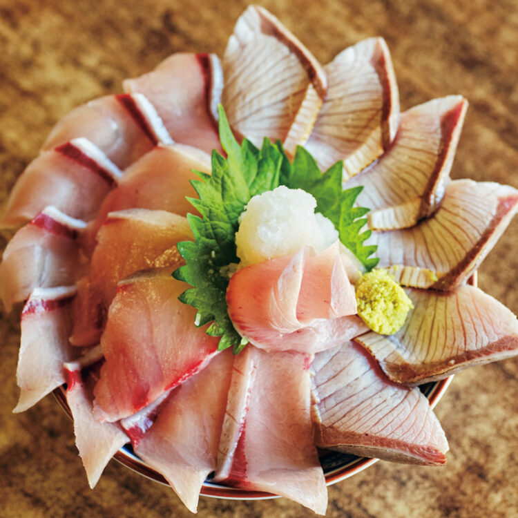 〈魚市場食堂〉のぶり丼。腹側、背側、大トロと様々な部位の切り身と、軽くあぶったあぶり刺身を、満開の花のように盛り付け。漁師汁付きの「ぶり丼定食」2,680円。