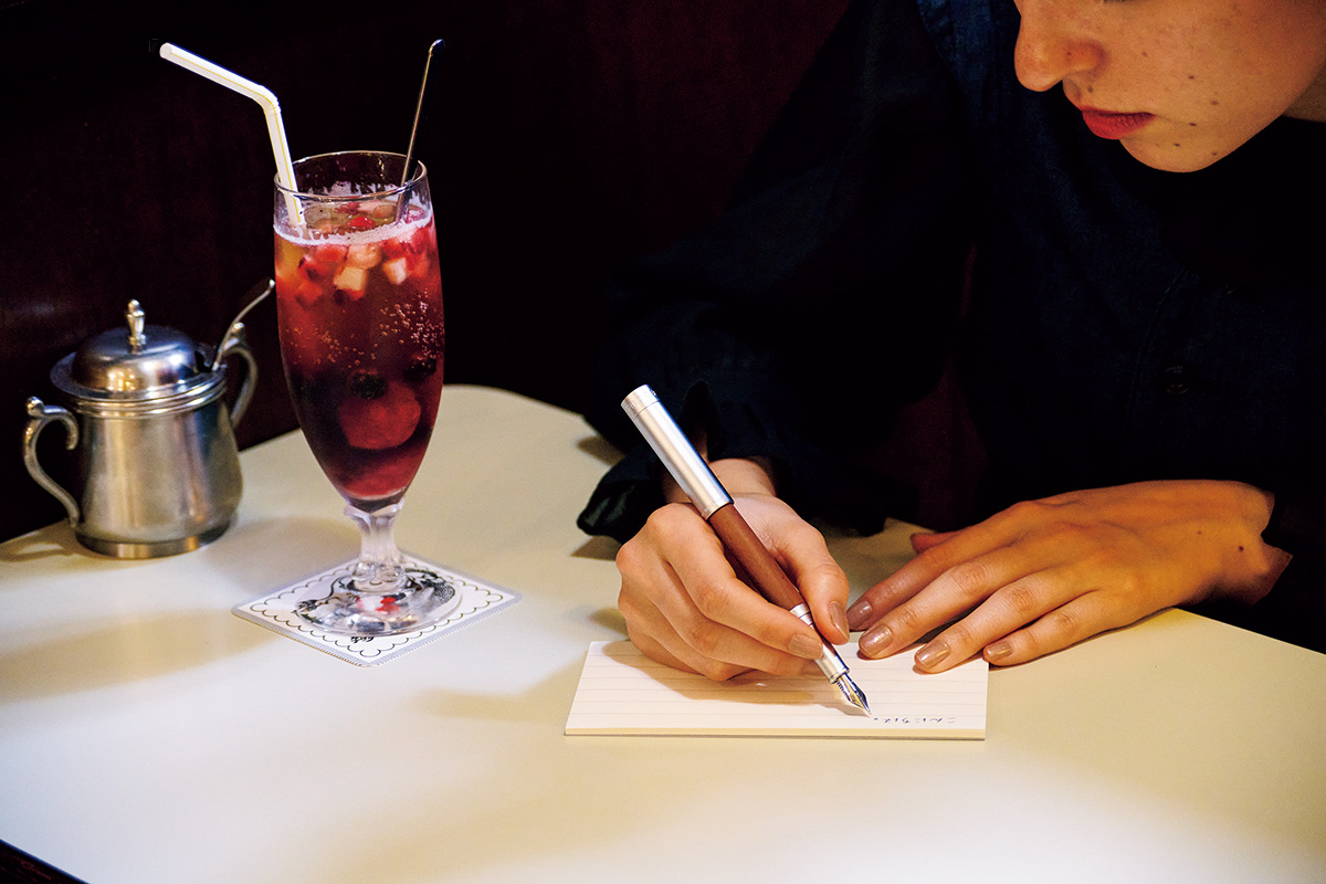 大好きな「ベリーベリーティーソーダー」（960円）を相棒に、まずは御礼状書きから。南ドイツ産の木材を使用した温かみのある万年筆は、同じ木目が存在せず、経年変化も楽しめる。リグヌム万年筆19,800円（ステッドラー｜ステッドラー日本 03-5835-2815）／便箋990円（パピエラボ 03-5411-1696）