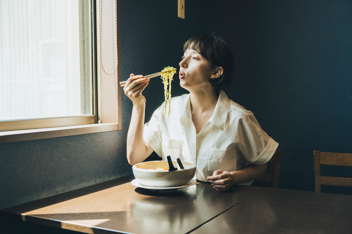 青森県八戸市の浜のだし薫る麺処 うみの宝の磯らぁ麺(うに入り)を食べる女性