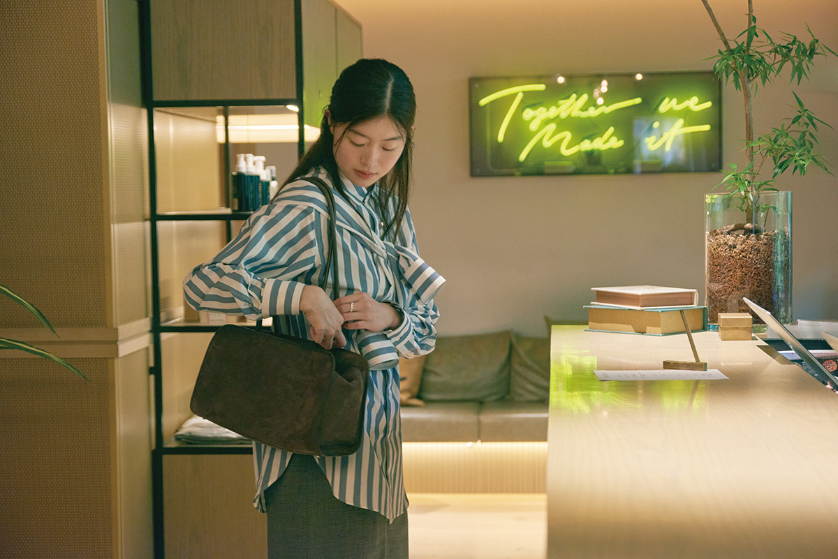 フロントには、ジェシー・ホーガンと小林一毅のアート作品が。フロントカウンターにもスピーカーが内蔵。バッグは上質で肩に掛けられるものを。ショルダーバッグ154,000円（エイトン ウィズ ナウハウストゥディオ｜エイトン青山 03-6427-6335）／ハートネックレス16,500円（ソワリー 06-6377-6711）