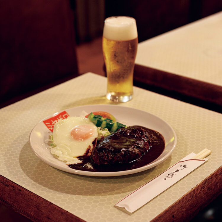 「ハンバーグ目玉焼き付」1,500円は、長年継ぎ足してコクが深まったデミグラスソースか和風ソースが選べる。生ビール750円。＋400円でライスと味噌汁のセットにも。