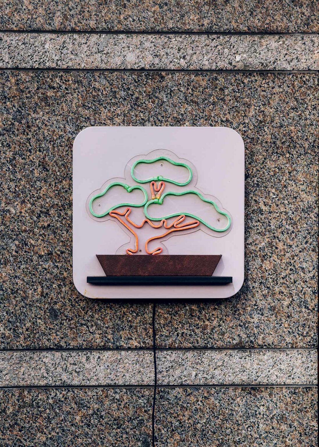 〈MATSUZAKI SHOTEN〉の入り口にあるネオンサインは、松の盆栽がモチーフ。大きな藤色ののれんと共に、お店の大切なシンボル。