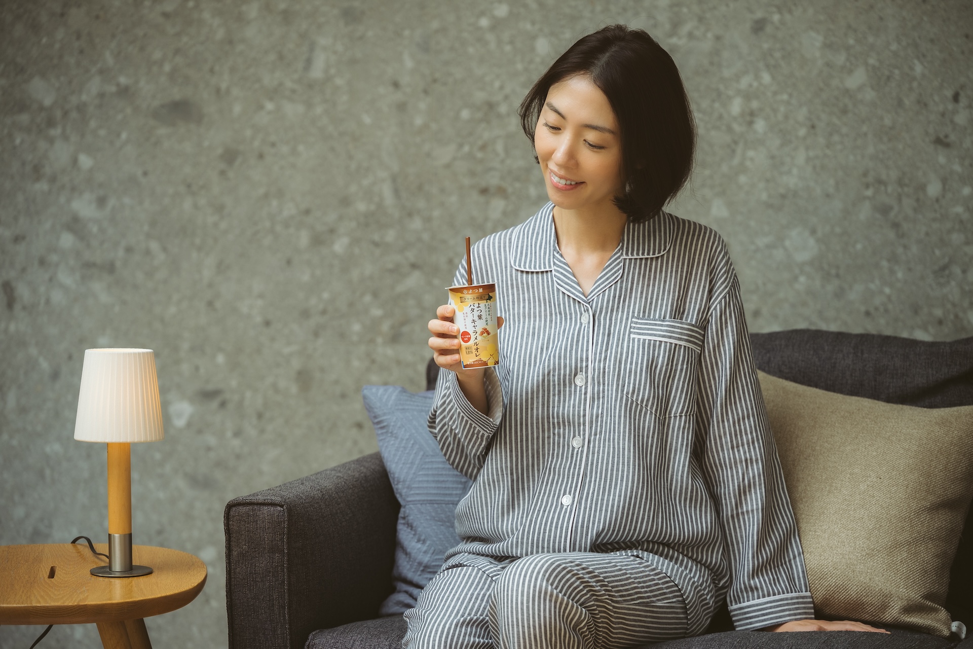 よつ葉乳業の「クリーム仕立てよつ葉バターキャラメルオレ」パジャマ姿の女性