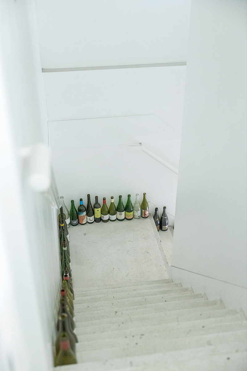 1.1階の入口から、専用の階段でアクセスする造り。ディスプレーされた空き瓶が並び、ワインバーのよう。 1.1階の入口から、専用の階段でアクセスする造り。ディスプレーされた空き瓶が並び、ワインバーのよう。