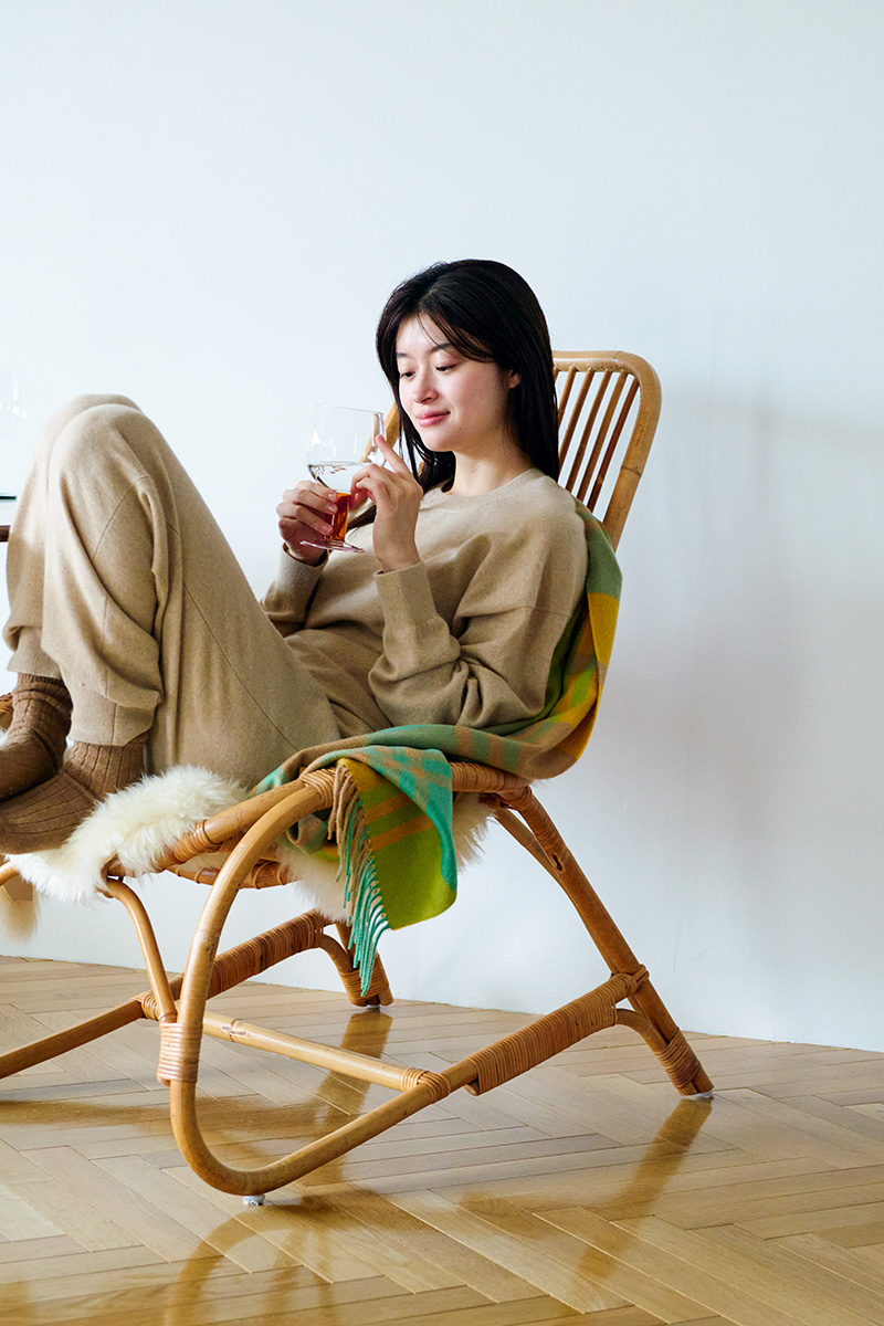 分を甘やかすリラックスウェアでまどろむ。カシミアのセットアップ 58,300 円(キャッシュアンドバルバ|エグジステンス info@cashbarba.com )/肩 から掛けたチェック柄ストール 93,500 円(ジョシュアエリス)、ソックス 10,780 円(パンセレラ|共に真下商事 03-6412-7081 )