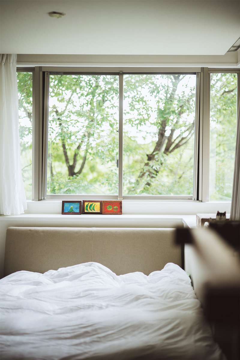 ベッドルームにも大きな窓があり、外に四季折々の景色が広がる。ペイントは石垣島時代の友人でアーティストの作品。 ベッドルームにも大きな窓があり、外に四季折々の景色が広がる。ペイントは石垣島時代の友人でアーティストの作品。