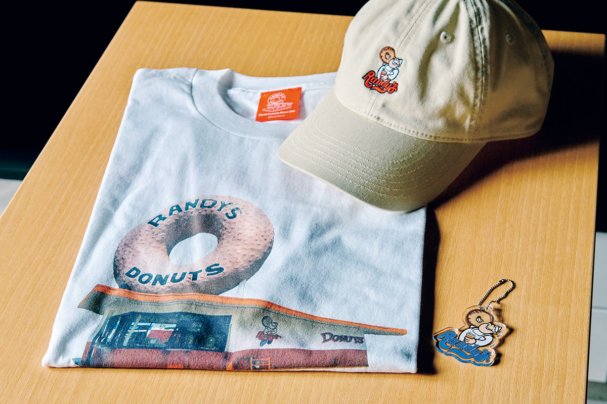 米国1号店かつロサンゼルスのランドマークとしても有名なイングルウッド店のプリントTシャツと「Randy’s Boy」の刺繍キャップとキーリング。Tシャツ5,940円、キャップ6,930円、キーリング880円(全てランディーズドーナツ https://randysdonuts.jp/) 米国1号店かつロサンゼルスのランドマークとしても有名なイングルウッド店のプリントTシャツと「Randy’s Boy」の刺繍キャップとキーリング。Tシャツ5,940円、キャップ6,930円、キーリング880円(全てランディーズドーナツ https://randysdonuts.jp/)