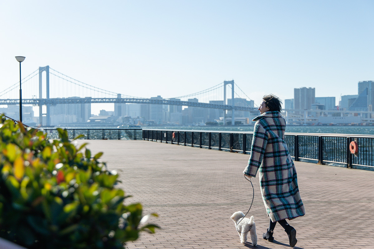 東京の臨海部で犬を散歩させる女性