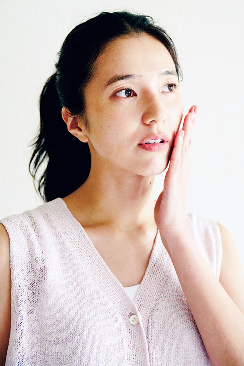 頬を触っている女性