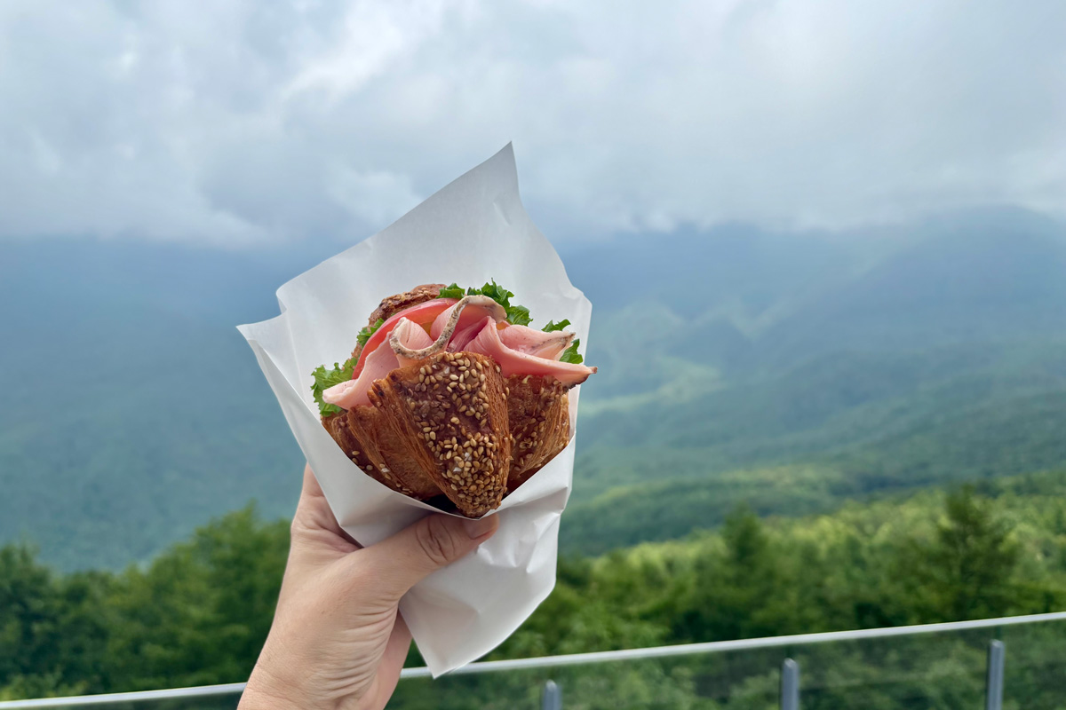 白馬岩岳マウンテンリゾート　長野　白馬村　〈THE CITY BAKERY白馬マウンテンハーバー〉限定の白馬村産の豚肉を使用した「プレッツェル クロワッサンサンド 白馬豚（1,350円）」。柔らかでジューシーなローストポークが味わい深い。