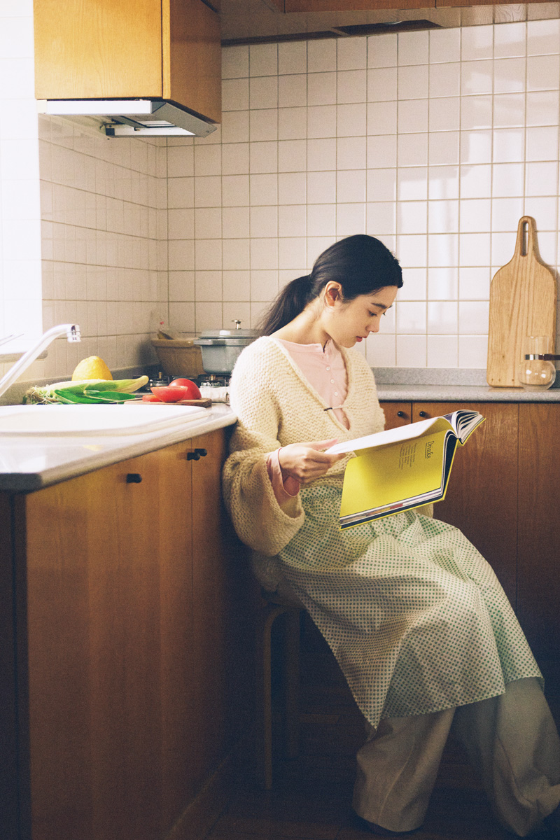 キッチンでレシピ本を読む女性