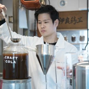 店内からは、ガラス越しに工房の様子を眺めることもできます。コーラの実を砕く粉砕機や薬棚など、小林さんの祖父から受け継いだ仕事道具がそこかしこに。